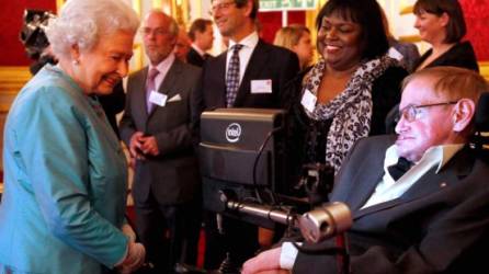 El científico Stephen Hawking y su enfermera, Patricia Dowdy, junto a la reina Isabel II. AFP/Archivo