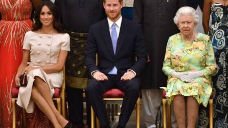 En esta foto de archivo tomada el 26 de junio de 2018, Meghan, duquesa de Sussex, el príncipe Harry de Gran Bretaña y la reina Isabel II de Gran Bretaña posan para una foto durante la ceremonia de entrega de premios de los jóvenes líderes de la reina en el Palacio de Buckingham.