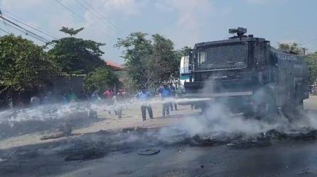 La tanqueta de la Policía Nacional se encargó de quitar los residuos de las llantas quemadas en la carretera internacional CA-4.
