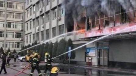 Bomberos chinos apagan las llaman del incendio en el internado.