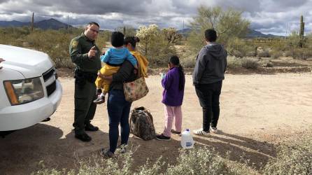 Agente de la patrulla fronteriza habla con una inmigrante hondureña junto a sus tres hijos de 2, 9 y 14 años en la frontera de Arizona con México.