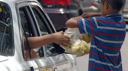 Foto de archivo: Un niño vende mangos a un taxista en Honduras.