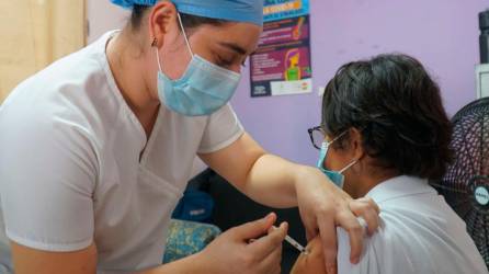 Biológico. Una enfermera aplica una vacuna anticovid a una señora.