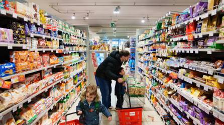 Stefano Baldo hace compras en el supermercado local con dos de sus seis hijos, en Bolzano, Italia, el mes pasado.