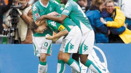 Bremen's Frank Baumann, center, celebrates his goal with Markus Rosenberg, left, and Boubacar Sanogo, right, challenge for the ball during the German first division Bundesliga soccer match between Werder Bremen and FC Schalke 04 in Bremen, Germany, Saturday, April 12, 2008. (AP Photo/Martin Meissner) ** NO MOBILE USE UNTIL 2 HOURS AFTER THE MATCH, WEBSITE USERS ARE OBLIGED TO COMPLY WITH DFL-RESTRICTIONS, SEE INSTRUCTIONS FOR DETAILS **