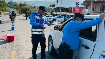 Agentes de Tránsito inspeccionan un vehículo en un retén.