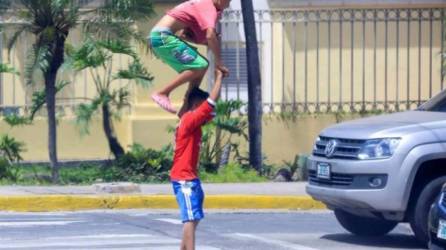 Dos niños hacen piruetas para ganar dinero en Honduras. Fotografía: EFE