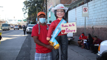 Un ciudadano con un monigote de la presidenta de Honduras en las afueras del estadio.