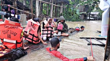 Prsonal de la guardia costera evacuando a los residentes locales de sus hogares inundados en una balsa improvisada en la ciudad de Panitan, provincia de Capiz.