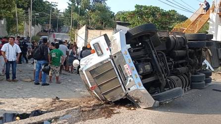 El camión tráiler que transportaba a migrantes por el sur de México yace de costado después del accidente.