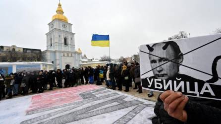 Un manifestante sostiene un cartel que representa al presidente ruso Vladimir Putin, firmado “asesino” durante una acción denominada #SayNOtoPutin en Kiev.