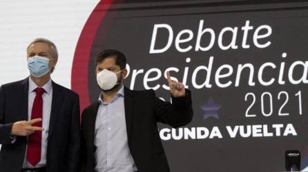 El candidato presidencial chileno Gabriel Boric, del partido Apruebo Dignidad (R), y el candidato presidencial chileno José Antonio Kast, posan ante un debate presidencial.