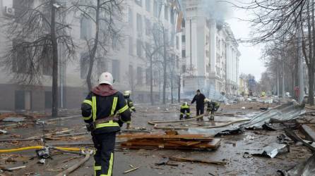 Los bomberos trabajan para contener un incendio ante edificio atacado durante el reciente bombardeo de Rusia.