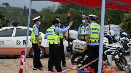 Los policías vigilan un puesto de control en la aldea de Langnan, en Wuzhou, cerca de donde se estrelló el vuelo.