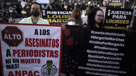 Periodistas y simpatizantes sostienen carteles mientras protestan por los asesinatos de sus colegas Lourdes Maldonado y Margarito Martínez, frente al edificio de la fiscalía federal en Tijuana, Baja California, México.