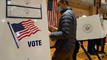 Foto de archivo de una persona votando en una urna de Nueva York.