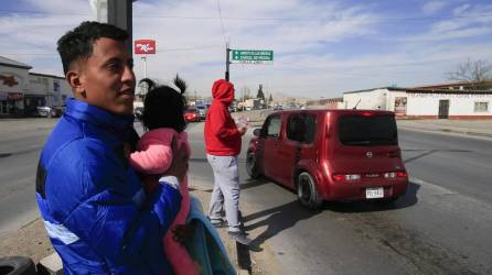 Migrante en México cargando en brazos a una niña pequeña | Fotografía de archivo