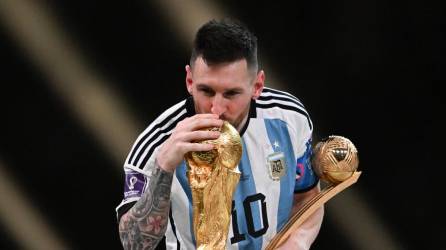 Lionel Messi besando el trofeo de la Copa del Mundo.