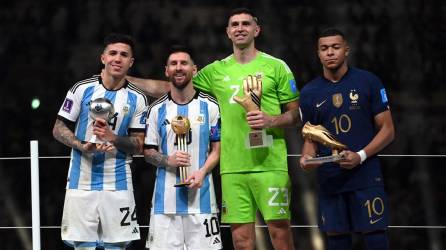 Enzo Fernández, Lionel Messi, Emiliano Martínez y Kylian Mbappé, posando con sus premios en el Mundial de Qatar 2022.