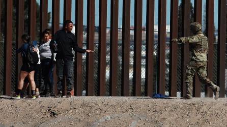 Integrantes de la Guardia Nacional de Estados Unidos impide el avance de un grupo de migrantes que intentan cruzar la frontera con México, en Ciudad Juárez.