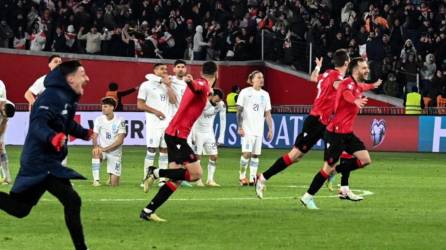 Jugadores de Georgia festejando a lo grande el pase histórico a la Euro ante el lamento de la plantilla de Grecia.