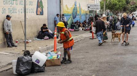 Migrantes y personas en situación de calle acuden por alimentos al Desayunador Salesiano Padre Chava en la fronteriza de Tijuana (México).