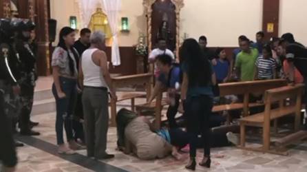 Una mujer llora la muerte de su familiar en una iglesia.