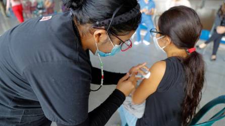 Una trabajadora de la salud vacuna a una menor de edad contra la covid-19, en Tegucigalpa (Honduras), en una fotografía de archivo.