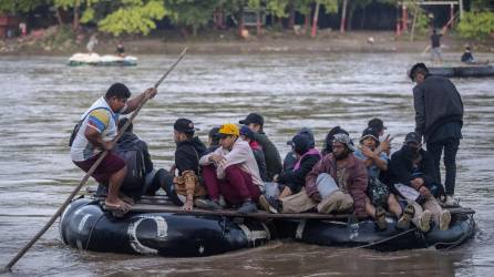 Los migrantes cruzan en balsas improvisadas el río Suchiate en la frontera de Guatemala y México.