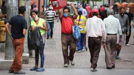 Un vendedor ambulante camina por el Parque Central de Tegucigalpa (Honduras).