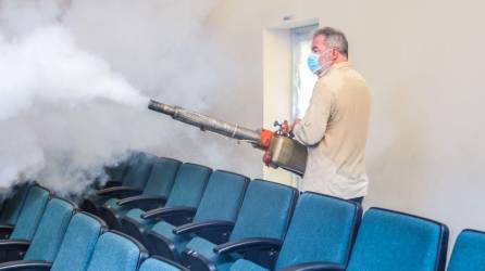 El alcalde de San Pedro Sula Fumigando uno de los espacios de la escuela.