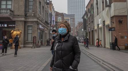Imagen de 2021 de una mujer con mascarilla en Wuhan, China, foco del coronavirus.