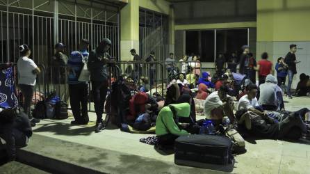 Migrantes de diferentes nacionalidades descansan en la Gran Central Metropolitana donde se preparan para salir en caravana con destino a los Estados Unidos, hoy en la ciudad San Pedro Sula (Honduras).