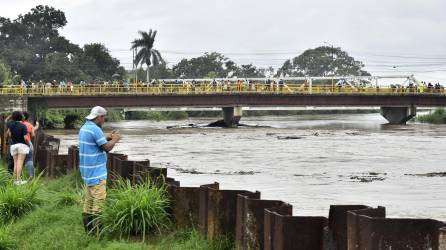 Pobladores observan el aumento del caudal del rio Chamelecón luego de que el gobierna emitiera alerta roja y ordenara evacuar las zonas bajas de la costa norte de Honduras debido al aumento de las lluvias por causa del huracán Julia, hoy en La Lima (Honduras). EFE/José Valle