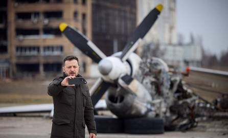 Presidente de Ucrania, Volodimir Zelenski, se toma una selfie frente a los restos del avión durante una visita en el segundo aniversario de la invasión rusa de Ucrania.