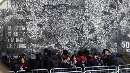 Personas se manifiestan durante un acto ciudadano en Conmemoración de los 50 años del Golpe de Estado teniendo de fondo una imagen del Salvador Allende, hoy a las afueras del Palacio de La Moneda en Santiago (Chile).