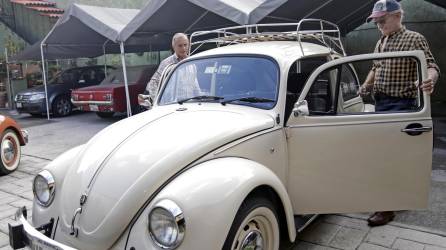 Benigno Piñas (d), propietario de un Volkswagen Sedán última edición, muestra su vehículo, el 28 de julio de 2023, en el estado de Puebla (México).
