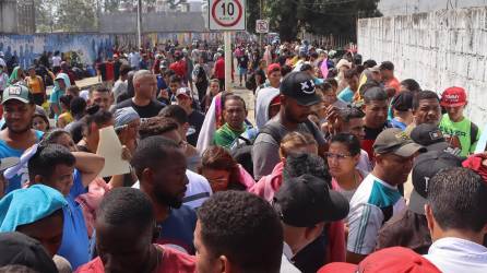 Los migrantes hacen fila por varias horas para obtener un permiso humanitario para transitar por México.