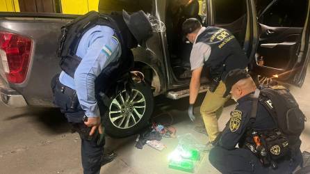 Policías inspeccionan vehículo que llevaba 15 kilos de cocaína en un compartimento falso, en Corinto, frontera de Honduras con Guatemala.