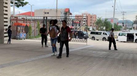 Estudiantes universitarios ingresan por el porton principal de la Universidad Nacional Autónoma de Honduras en el valle de Sula.