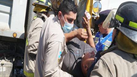 Los elementos del Cuerpo de Bomberos rescataron al motorista de la volqueta y lo trasladaron a un hospital.