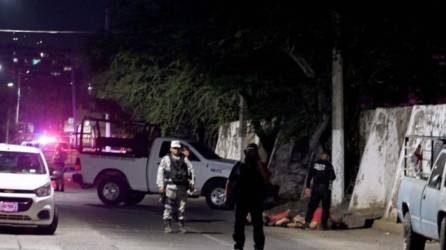 Agentes policiales mexicanos cubren la escena donde fueron encontrados los cuerpos.
