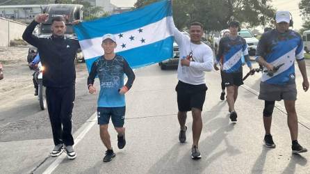 Shin Fujiyama en su recorrido desde Choloma a Chamelecón, acompañado de su equipo, quienes sostiene una bandera de Honduras.