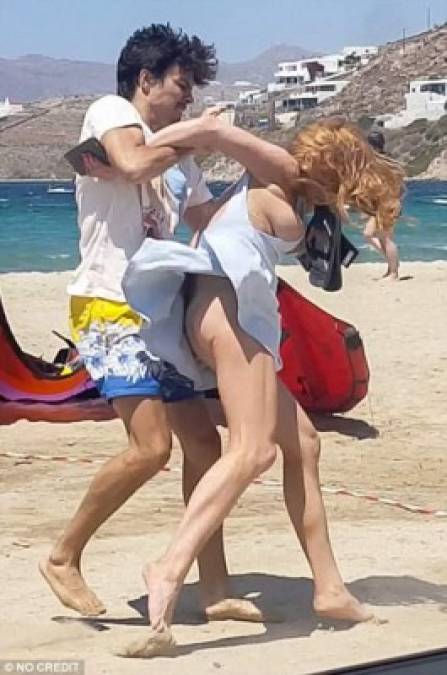 Las imágenes causan mucha impresión, ya que se ve cómo la actriz sale del auto que comparten en la playa en Grecia y él la reduce a la fuerza para quitarle el celular.