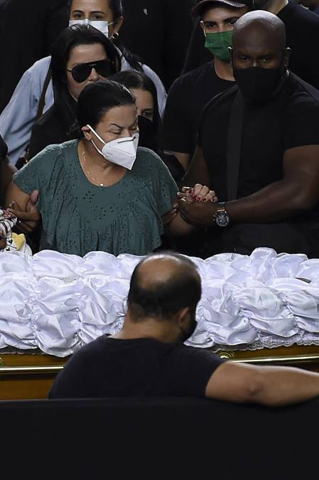Ruth Moreira Dias (izq.), madre de la cantante brasileña Marilia Mendonca, llora junto a su ataúd durante su velorio en el polideportivo Arena Goiania, en Goiania, estado de Goias, Brasil.