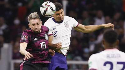 Héctor Herrera de México disputa el balón con Miles Robinson de Estados Unidos durante el partido eliminatorio en el estadio Azteca.