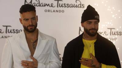 El cantante colombiano Maluma junto a su figura de cera.