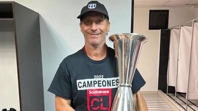 Pedro Troglio, feliz posando con su primer trofeo internacional como entrenador del Olimpia.