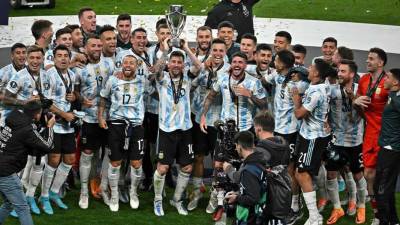 Lionel Messi levantando el trofeo de la Finalissima y sus compañeros celebrando.