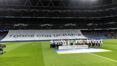 Los jugadores del Real Madrid y de la Real Sociedad posan con un mensaje en apoyo a Ucrania, en el estadio Santiago Bernabéu.